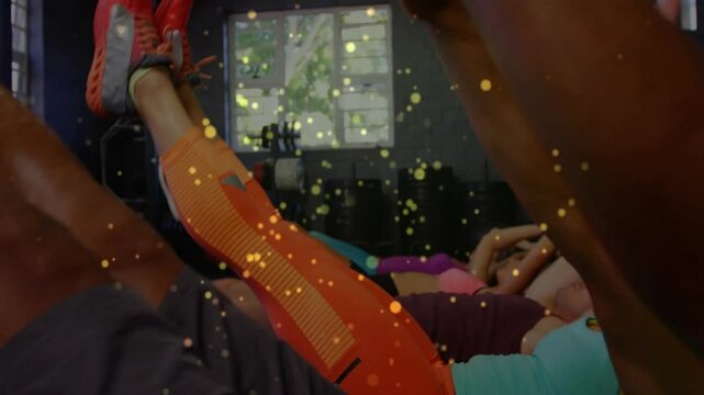 Fitness group starting V-up exercise engaging abs after trainer cue with golden particles flowing