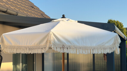 A stylish bohemian patio umbrella with fringe for summer relaxation
