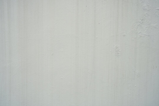 A light, off-white wall with subtle vertical streaks and a slightly weathered texture. Ideal as a minimalist background, offering a clean yet slightly rustic backdrop for various design needs