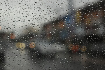 rain in the city blur background, water drop on windshield of car