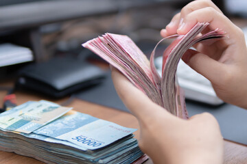 Close-up photograph of hands counting money for financial articles, photo graphic, business website...