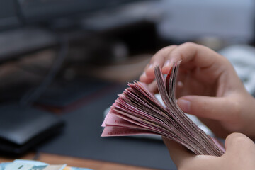 Close-up photograph of hands counting money for business finance and economy concepts banner or web...