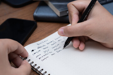 Candid close-up of hand writing in notebook lifestyle photography for business blog educational...