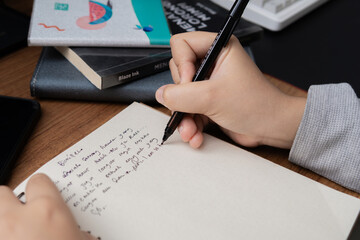 Photographic close-up of a hand writing in a notebook for business lifestyle and educational...