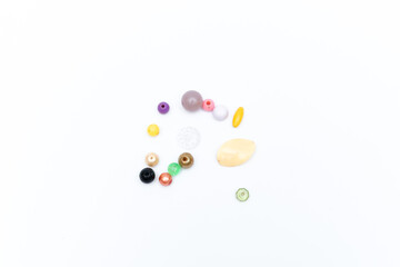 Minimalist flat lay photo of colorful crafting beads for DIY jewelry projects on a clean white background