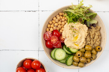 Top view of colorful Buddha bowl with quinoa, hummus, chickpeas, vegetables. Healthy vegetarian dish