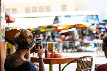 Tourist taking pictures of traditional market in kratie, cambodia