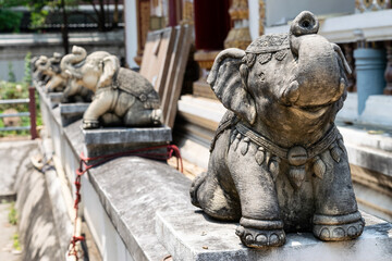 Naklejka premium Stone elephant statues guarding buddhist temple in bangkok, thailand
