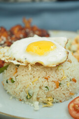 Fried rice topped with a sunny-side-up egg and side items