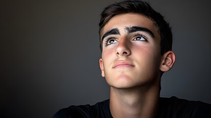 Thoughtful Teenager Portrait, Young Man Looking Up, Hopeful Expression, Studio Shot