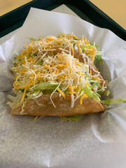 Delicious crunchy tacos topped with lettuce and cheese.