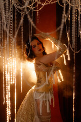 Young Caucasian circus performer or burlesque dancer in golden vintage corset, front view, posing...