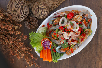 Spicy Thai Seafood Salad with Crab, Shrimp, Shellfish, and Herbs on White Plate