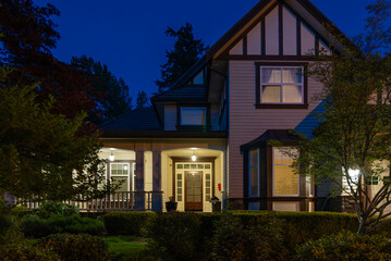 Two story stucco luxury house with nice Spring blossom landscape at night in Vancouver, Canada, North America. May 2025.