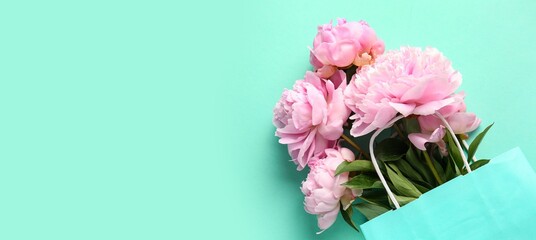 Shopping bag with beautiful pink peonies on turquoise background with space for text © Pixel-Shot