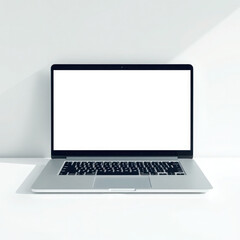 Sleek silver laptop with blank screen sits on a minimalist white desk.