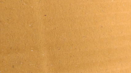 Background of brown kraft paper or cardboard texture. Brown kraft paper texture macro closeup with grains texture.