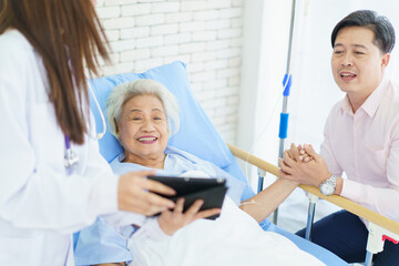 Man visiting his elderly mother in recovery ward in hospital.