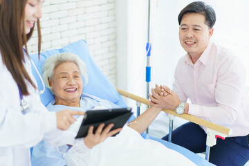 Man visiting his elderly mother in recovery ward in hospital.