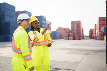 Shipyard workers are working together and checking a containers in container yard.