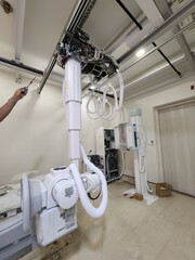A high-tech X-ray machine in a medical room, featuring advanced equipment and intricate wiring. It’s ready to provide clear and detailed imaging for diagnostics.