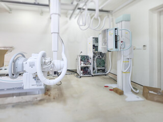A high-tech X-ray machine in a medical room, featuring advanced equipment and intricate wiring. It’s ready to provide clear and detailed imaging for diagnostics.