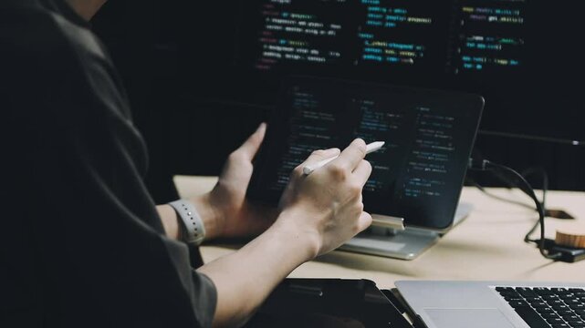 Male programmer working on new project.He working late at night at the office.