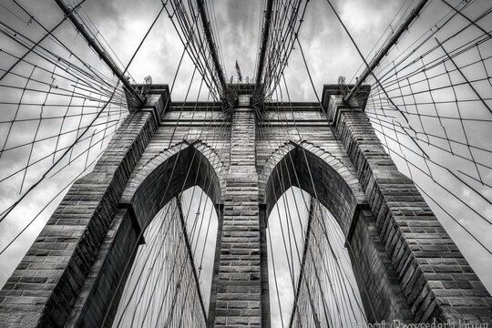 Brooklyn Bridge towers above with intricate cable designs and striking architecture in New York City, Brooklyn Bridge, New York City - Powered by Adobe