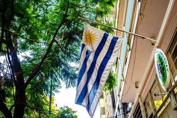 Uruguayan flag waving with green trees in the background at the Uruguayan embassy in Mexico