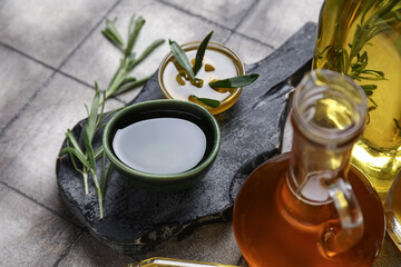 Bowls of fresh olive oil on grey tile background