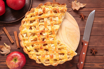 Board with delicious apple pie and ingredients on wooden background