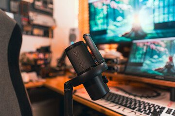 Modern podcast setup with professional microphone on boom arm in cozy home studio, featuring blurred monitors and wooden blinds background. Creative workspace inspiration. © Redd Molecule