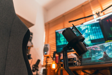 Modern podcast setup with professional microphone on boom arm in cozy home studio, featuring blurred monitors and wooden blinds background. Creative workspace inspiration.