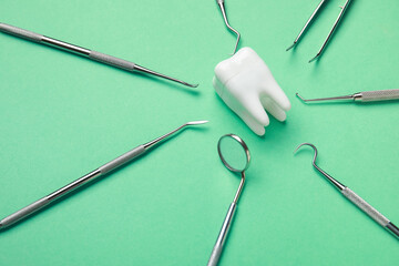 Tooth model with dental tools on green background. World Dentist Day