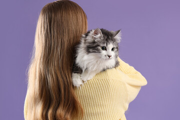 Owner holding cute cat after sterilization on lilac background