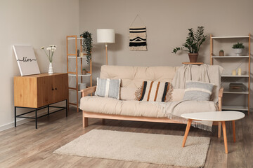 Stylish interior of living room with comfortable beige sofa