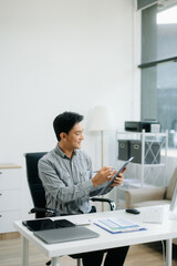 Fototapeta premium Young businessman working with working notepad, tablet and laptop documents talking