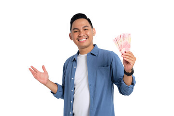 Cheerful young Asian man in casual shirt holding money with happy facial expression isolated on...