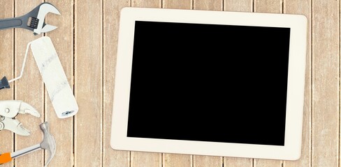 Tools and tablet on wooden background