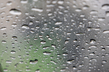 close-up, full-frame shot of numerous water droplets of varying sizes clinging to a glass surface