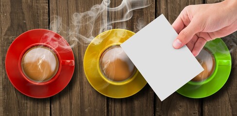 Hand holding page over colorful tea cups