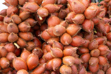 pile of Salacca fruits, also known as snake fruit, showcasing their unique reddish-brown, scaly skin and thorny appearance.