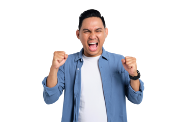 Big win. Excited young Asian man in casual shirt celebrating success with raised fist isolated on transparent background