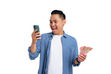 Excited young Asian man in casual shirt using smartphone, holding money, celebrating financial success isolated on transparent background