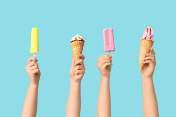 Female hands with different sweet ice-cream on blue background