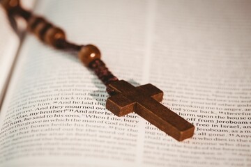 Wooden cross on open bible pages