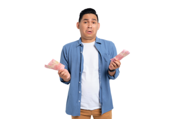 Surprised young Asian man in casual shirt holding money and looking at camera with confused expression isolated on transparent background
