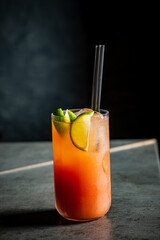 A vibrant tropical cocktail filled with ice and lime slices captures the essence of relaxation