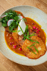 Crispy fritters drizzled with tangy sauce and fresh herbs enhance the dish's appeal