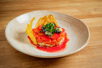 This dish showcases a vibrant arrangement of fresh tomatoes, garnishes, and crispy elements